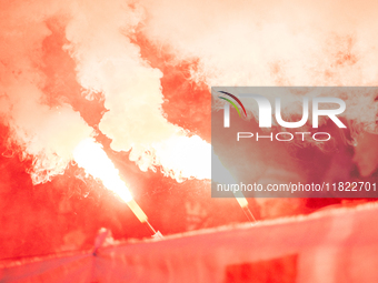 Cracovia fans attend the game between KS Cracovia and Zaglebie Lubin in Krakow, Poland, on November 29, 2024. Team supporters burn smoke fla...