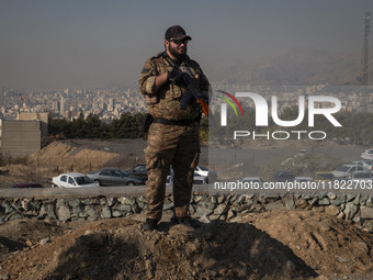 An armed IRGC special force military personnel monitors an area during a funeral for General Kioumars Pourhashemi, a commander of the Islami...