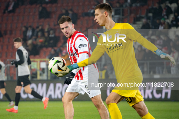 Benjamin Kallman and Zaglebie goalkeeper Dominik Hladun participate in the game between KS Cracovia and Zaglebie Lubin in Krakow, Poland, on...