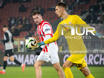 Benjamin Kallman and Zaglebie goalkeeper Dominik Hladun participate in the game between KS Cracovia and Zaglebie Lubin in Krakow, Poland, on...