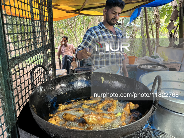 A man fries hot chili peppers at a roadside snack stand in Konni, Pathanamthitta, Kerala, India, on April 5, 2024. 