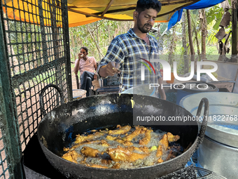 A man fries hot chili peppers at a roadside snack stand in Konni, Pathanamthitta, Kerala, India, on April 5, 2024. (