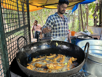 A man fries hot chili peppers at a roadside snack stand in Konni, Pathanamthitta, Kerala, India, on April 5, 2024. (