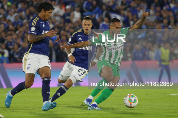 Juan Carlos Pereira and Leonardo Castro of Millonarios and Andres Sarmiento of Atletico Nacional fight for the ball during the match on date...