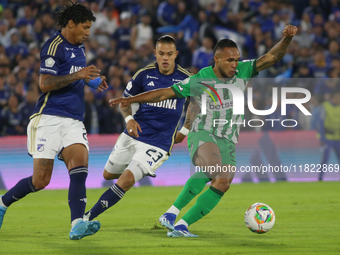 Juan Carlos Pereira and Leonardo Castro of Millonarios and Andres Sarmiento of Atletico Nacional fight for the ball during the match on date...