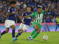 Juan Carlos Pereira and Leonardo Castro of Millonarios and Andres Sarmiento of Atletico Nacional fight for the ball during the match on date...