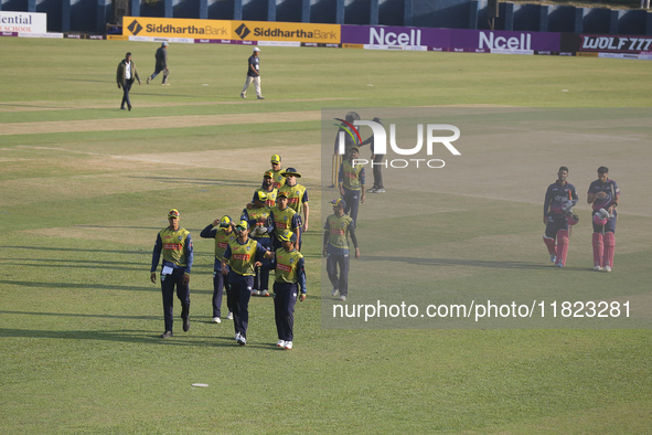 Players from Janakpur Bolts (Pink) and Biratnagar Kings (Yellow) walk off the pitch after the completion of an over during the Nepal Premier...