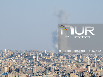 Thick columns of smoke were seen rising over the city of Aleppo on November 30, 2024, following a series of airstrikes conducted by Syrian w...