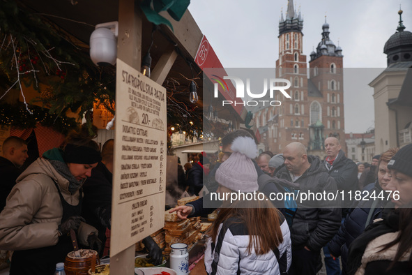 Touriststs visit traditional Christmas market at the Main Square in Krakow, Poland on Nobember 30th, 2024.  