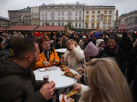 Tourists eat traditional food at Christmas market at the Main Square in Krakow, Poland on Nobember 30th, 2024.  (