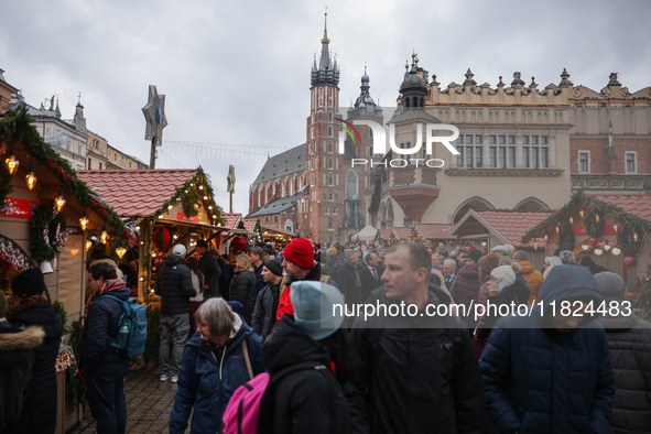 Touriststs visit traditional Christmas market at the Main Square in Krakow, Poland on Nobember 30th, 2024.  