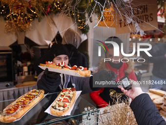 Traditional toasted baguettes with toppings (zapiekanki) are sold at Christmas market at the Main Square in Krakow, Poland on Nobember 30th,...