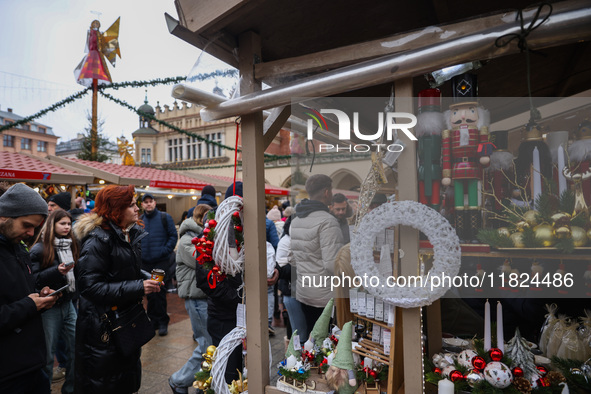 Touriststs visit traditional Christmas market at the Main Square in Krakow, Poland on Nobember 30th, 2024.  