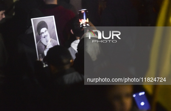 Mourners attend a vigil to honor Hezbollah's late chief Hassan Nasrallah at the site where he was killed in an Israeli air strike in the Har...