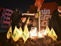 Mourners attend a vigil to honor Hezbollah's late chief Hassan Nasrallah at the site where he was killed in an Israeli air strike in the Har...