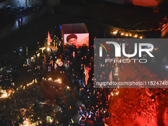 Mourners attend a vigil to honor Hezbollah's late chief Hassan Nasrallah at the site where he was killed in an Israeli air strike in the Har...