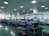 Workers install chips, resistors, and other components on a circuit board in a workshop in Fuyang, China, on November 30, 2024. (