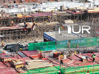 Workers speed up the construction of basic works at the construction site of the urban village renovation project in Chongqing, China, on No...