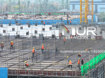 Workers speed up the construction of basic works at the construction site of the urban village renovation project in Chongqing, China, on No...