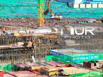 Workers speed up the construction of basic works at the construction site of the urban village renovation project in Chongqing, China, on No...