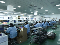 Workers install chips, resistors, and other components on a circuit board in a workshop in Fuyang, Anhui province, China, on November 30, 20...