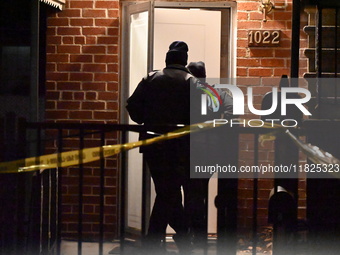 NYPD crime scene investigators search for evidence at the scene where a 30-year-old man is killed in an assault in the Throggs Neck section...