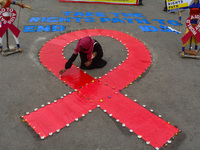 An activist from the Thalassemia and AIDS Prevention Society lights candles around a giant AIDS sign during a demonstration organized in Kol...