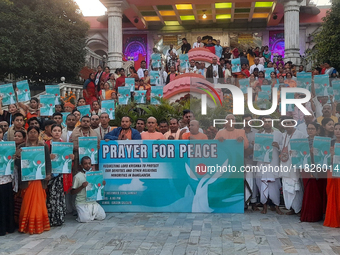 Members of the International Society for Krishna Consciousness (ISKCON) and devotees hold placards at ISKCON Temple in Siliguri, India, on D...