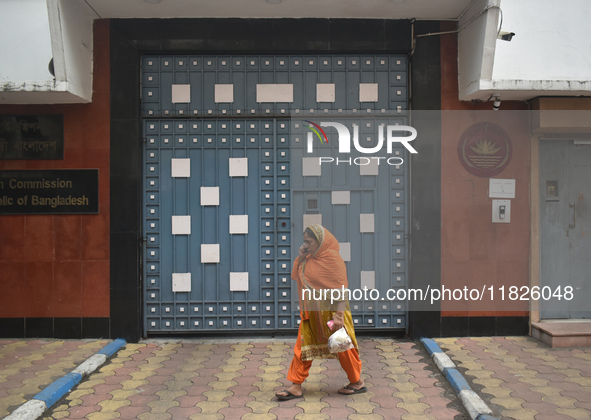 A woman talks on her mobile as she passes next to the Bangladesh High Commissioner's office in Kolkata, India, on December 1, 2024. Security...