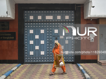 A woman talks on her mobile as she passes next to the Bangladesh High Commissioner's office in Kolkata, India, on December 1, 2024. Security...