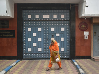 A woman talks on her mobile as she passes next to the Bangladesh High Commissioner's office in Kolkata, India, on December 1, 2024. Security...