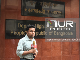 A media person stands in front of the Bangladesh High Commissioner's office during a broadcast in Kolkata, India, on December 1, 2024. Secur...