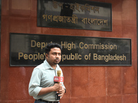 A media person stands in front of the Bangladesh High Commissioner's office during a broadcast in Kolkata, India, on December 1, 2024. Secur...