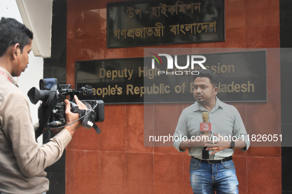 A media person stands in front of the Bangladesh High Commissioner's office during a broadcast in Kolkata, India, on December 1, 2024. Secur...