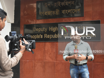 A media person stands in front of the Bangladesh High Commissioner's office during a broadcast in Kolkata, India, on December 1, 2024. Secur...