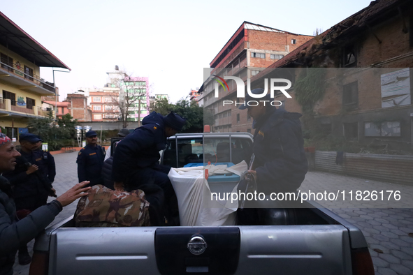 Nepal Police personnel load a ballot box into the vehicle to transport it to a vote-counting center after the completion of voting in Nepal'...