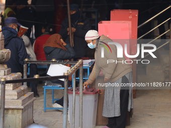 A Nepali voter casts a vote in the local by-election at a polling center in Kathmandu, Nepal, on December 1, 2024. A periodic election to el...