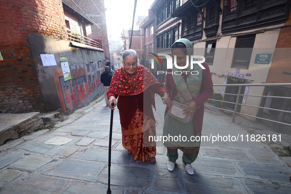 An elderly voter walks towards a nearby polling center to exercise her franchise in the local level by-election held in Kathmandu, Nepal, on...