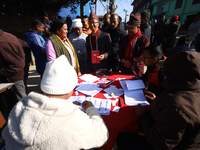 Candidates contesting the election and voters search for their registration numbers before heading to the polls in Nepal's local by-election...