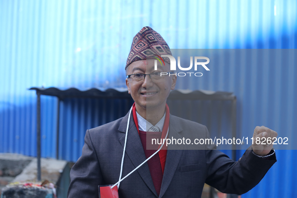 A Nepali candidate contesting the election shows his inked nail after casting his vote at a polling center in Kathmandu, Nepal, on December...