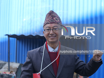 A Nepali candidate contesting the election shows his inked nail after casting his vote at a polling center in Kathmandu, Nepal, on December...