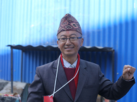 A Nepali candidate contesting the election shows his inked nail after casting his vote at a polling center in Kathmandu, Nepal, on December...