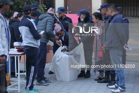 Election officials pack a ballot box to dispatch it to a counting center after the completion of voting in a local by-election held in Kathm...