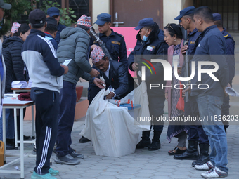 Election officials pack a ballot box to dispatch it to a counting center after the completion of voting in a local by-election held in Kathm...