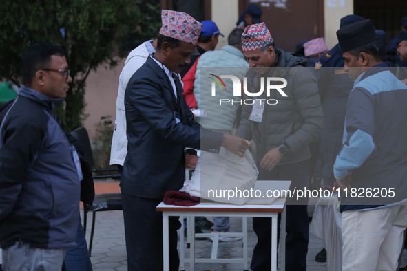 Election officials pack other essentials to dispatch them to a counting center after the completion of voting in a local by-election in Kath...