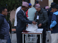 Election officials pack other essentials to dispatch them to a counting center after the completion of voting in a local by-election in Kath...