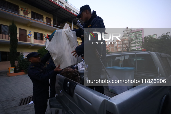 Nepal Police personnel load a ballot box into the vehicle to transport it to a vote-counting center after the completion of voting in Nepal'...