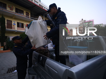 Nepal Police personnel load a ballot box into the vehicle to transport it to a vote-counting center after the completion of voting in Nepal'...