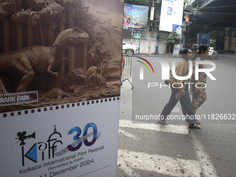 Women pass next to a poster of the International Film Festival in Kolkata, India, on December 1, 2024. The International Film Festival start...