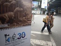 Women pass next to a poster of the International Film Festival in Kolkata, India, on December 1, 2024. The International Film Festival start...